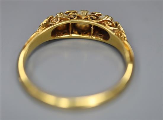 An early 20th century yellow metal and three stone split pearl set half hoop ring, with diamond chip spacers, size P,